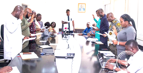 Dr Okoe-Boye (head of table) swearing in members of the committee